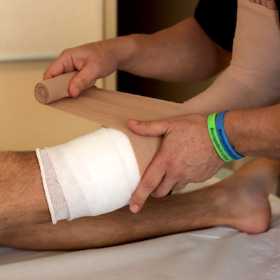 Donato Lecci effettua il bendaggio alla gamba di un paziente